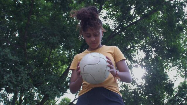 Jogadora de futebol olhando pra bola s&eacute;ria negra afro brazil