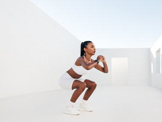 Obraz premium Female fitness influencer doing sit-ups in a white outdoor studio. Young woman doing workout outdoors. Female in white fitness attire is doing exercises for her glutes.