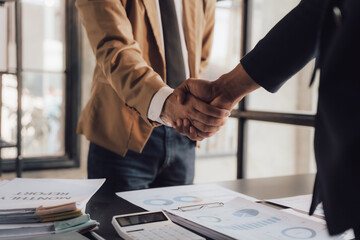 Asian male interviewer and interviewee shaking hands for job interview Businessmen shaking hands in modern office Greeting agreement concept.