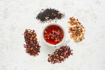 Composition with glass and heaps of dried fruit tea on white table