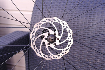 Bicycle disk brake rotor plate on bicycle wheel close up photo. Repairing bike at home. Sporting...