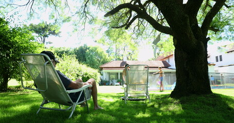 Family backyard home garden setting, man relaxing outside