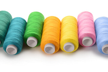 Set of colorful thread spools on white background, closeup