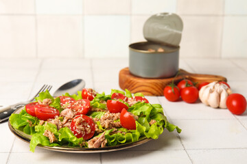 Plate with delicious tuna salad on white tiled table