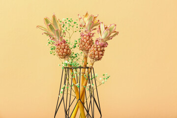Vase with decorative pineapples on beige background, closeup