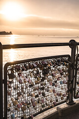 Beautiful sunrise view from Imperia statue at harbor entrance through fence with locks and Lake...