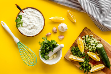 Bowl of dip sauce sour cream with herbs and garlic. Homemade dairy product background