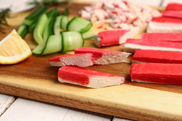 Wooden board with tasty crab sticks on table, closeup © Pixel-Shot