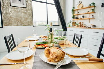 table served with grilled chicken and vegetables near bottle of wine in modern kitchen. 