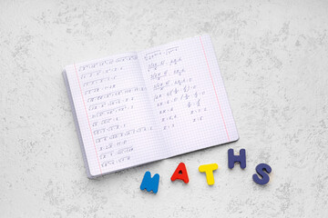 Copybook with formulas and text MATHS on white grunge background