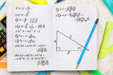 Copybook with maths formulas and pen, closeup