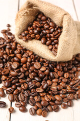 Fototapeta premium Bag with coffee beans on light wooden background