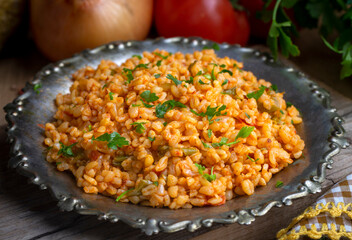 Traditional turkish bulgur pilaf with tomato sause in plate (Turkish name; meyhane pilavi)
