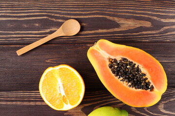 Mockup wooden spoon and fresh papaya on table