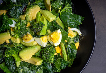 Avocado salad with broccoli, boiled egg in white vintage bowl on light salad