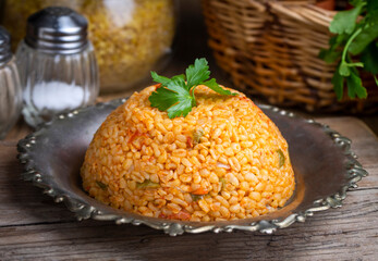 Traditional turkish bulgur pilaf with tomato sause in plate (Turkish name; meyhane pilavi)