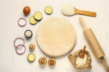 Raw dough and ingredients for preparing vegetable pie on white background