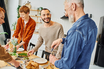 bearded man opening wine near happy family setting delicious supper in kitchen.