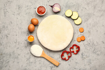 Raw dough and ingredients for preparing vegetable pie on grey grunge background