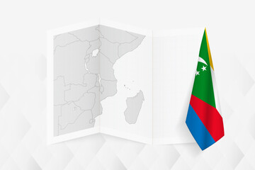 A grayscale map of Comoros with a hanging Comoros flag on one side. Vector map for many types of news.