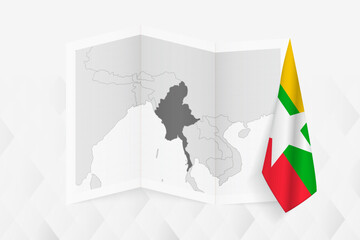 A grayscale map of Myanmar with a hanging Myanmar flag on one side. Vector map for many types of news.