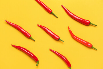 Fresh hot chili peppers on yellow background