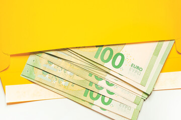 Euro cash in an envelope. 100 euro banknotes in a yellow envelope