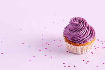 Tasty cupcake on purple background