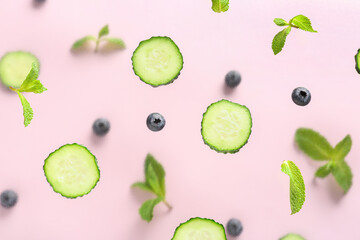 Slices of cucumber with blueberry and mint on lilac background