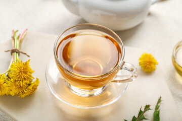 Glass cup of healthy dandelion tea on white background
