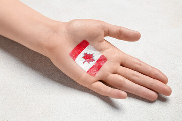 Female hand with drawn flag of Canada on white background, closeup