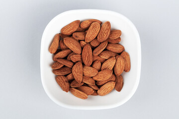 A bowl of almonds on the grey table. Healthy snack with nuts.