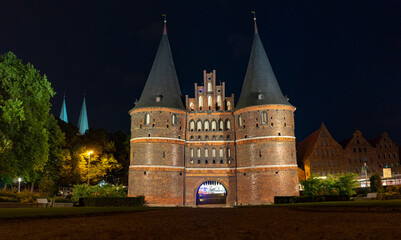 Fototapeta na wymiar Holstentör (Holstengate) at night. City gate of Lubeck (Hanseatic city of Lübeck). Schleswig-Holstein, Germany.