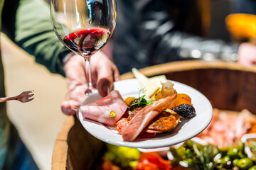 Food on a plate with wine in hand