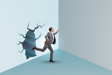Fototapeta premium Businessman breaking through the wall