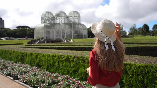 Beautiful girl with hat visiting the Botanical Garden of Curitiba, Parana, Brazil. Slow motion.