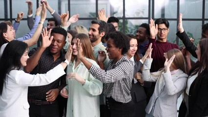 Smiling multiethnic colleagues celebrating common business success or victory in the office.