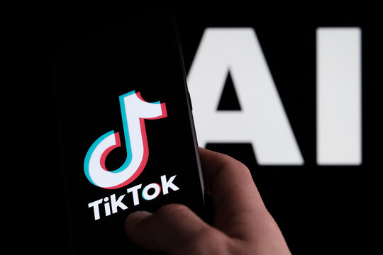 TikTok logo seen on smartphone and AI letters on the background. Concept for TikTok Artificial Intelligence. Stafford, UK, May 2, 2023
