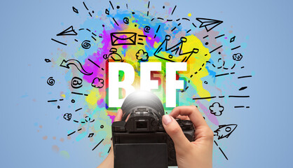 Close-up of a hand holding digital camera with abstract drawing