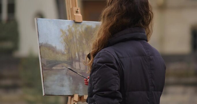Female street art painter has some sketch practice with Paris city landscape. Experienced European woman artist draws new painting near the river. Painter and her lifestyle hobby leisure Generative AI