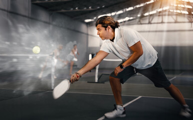 Fototapeta na wymiar Sporty man pickleball tennis player trains on the indoor court using a racket to hit the ball Generative AI