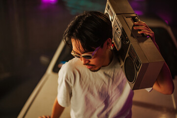 Fashionable man using boombox.