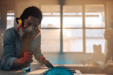 Focused woman working with table saw.