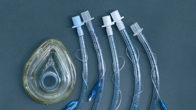 set for tracheal intubation on a blue background close-up. medical mask, endotracheal tubes of different diameters. medical consumables, medical instruments and equipment for emergency Generative AI
