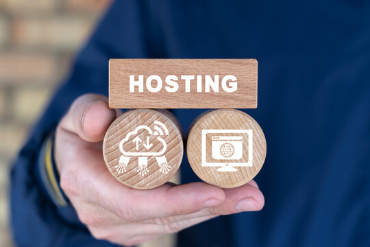 Concept of web hosting, domains name registration, internet technology. Man holding wooden blocks with icons and word: HOSTING. Internet database.