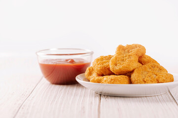 Chicken nuggets with ketchup on white