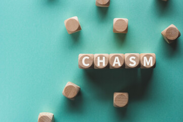 There is wood cube with the word CHASM.It is as an eye-catching image.