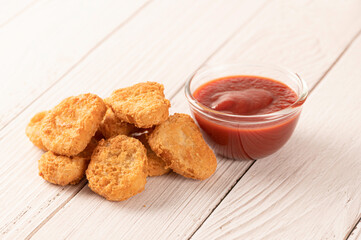 Chicken nuggets with ketchup on wooden table