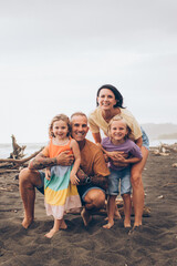 family hugging their kids on the beach