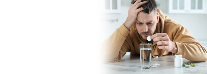 Man taking medicine for hangover at table in kitchen, space for text. Banner design